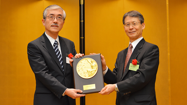 2014年10月10日に行われた表彰式にて、日本証券アナリスト協会の大場会長(右)と松原三井物産執行役員CFO補佐兼経理部長